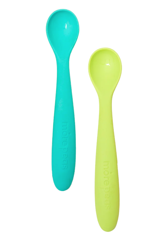 A blue and a green silicone baby spoon on white background